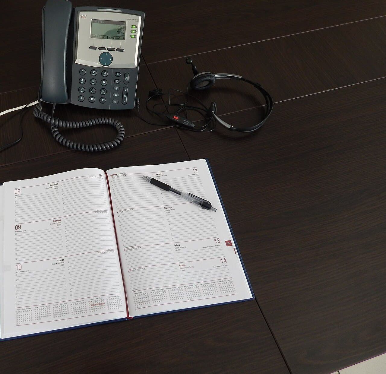 Phone, headset and diary on a desk